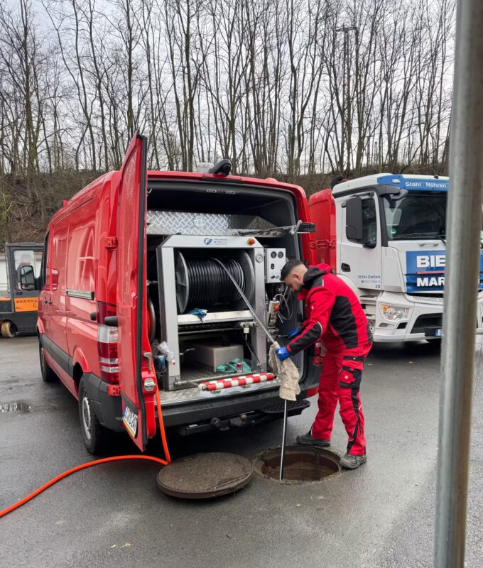 Kanalreiniger spült Kanal mit Spülfahrzeug für Rohrreinigung und Kanalreinigung