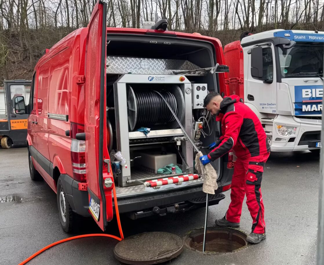 Kanalreiniger spült Kanal mit Spülfahrzeug für Rohrreinigung und Kanalreinigung