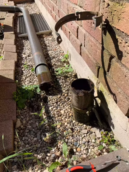Dachwasser leitung leigt auf den Boden neben einer Wand, gespült und gereinigt.