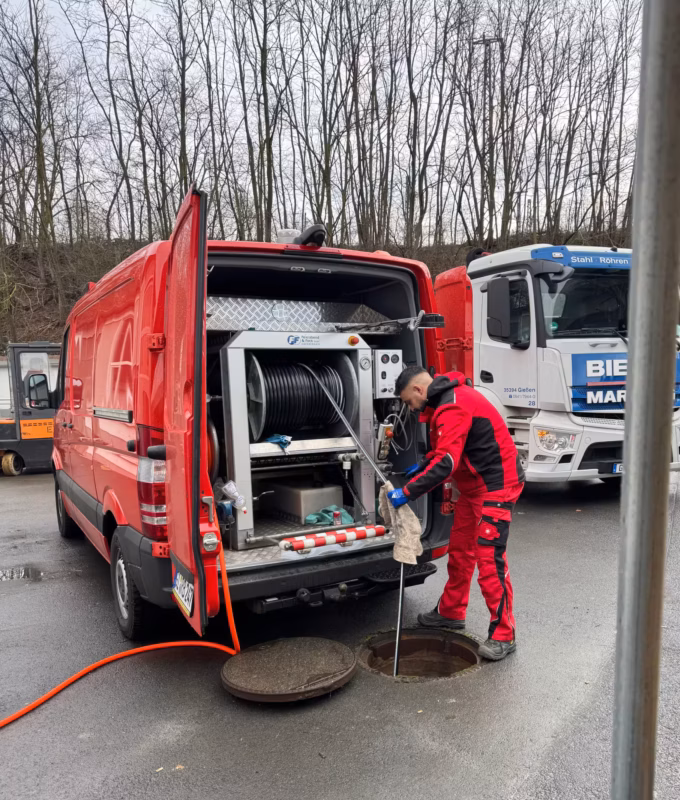 Kanalreiniger spült Kanal mit Spülfahrzeug für Rohrreinigung und Kanalreinigung